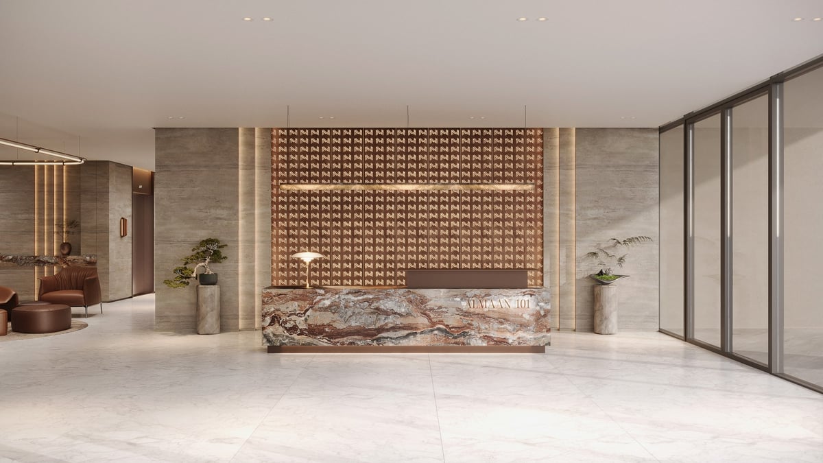 Almaan 101 — A stone reception desk anchors the entrance against a patterned timber backdrop.