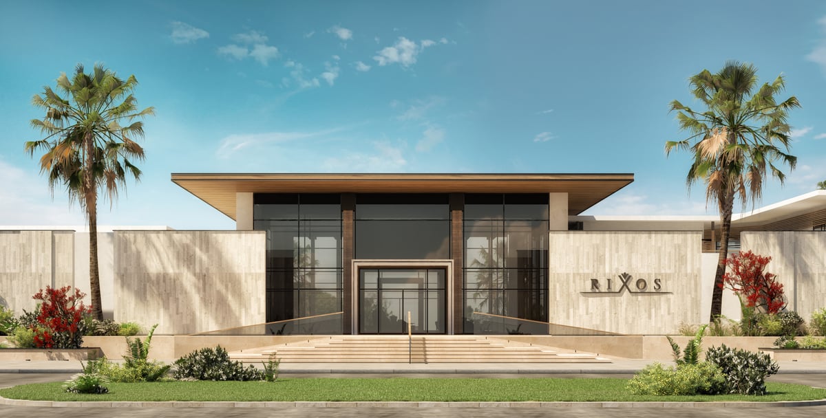 Rixos Magawish — A broad roof and restrained entrance wall compress the arrival before the resort opens towards the water.